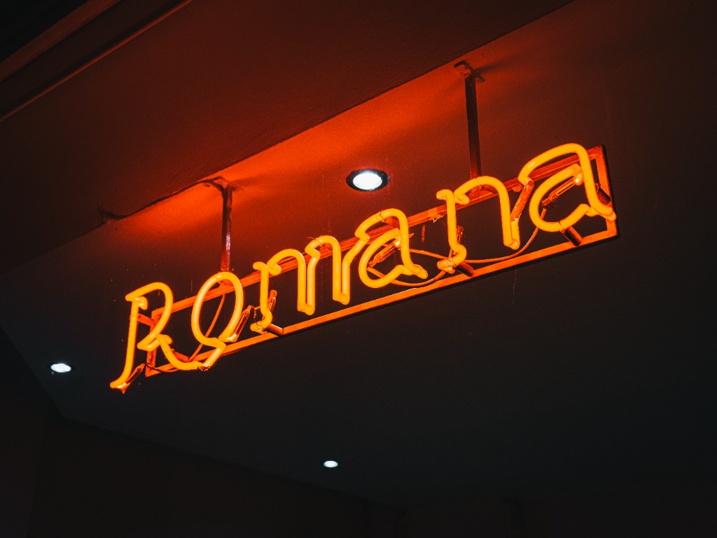 Neon Romana Pizzaria — sinalética no espaço